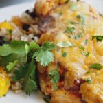 Baked Salsa Chicken with cheese and cilantro on white plate.