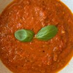 hearty tomato basil soup in white bowl.