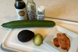 Cucumber Smoked Salmon and Avocado with Tamari on White Cutting Board.