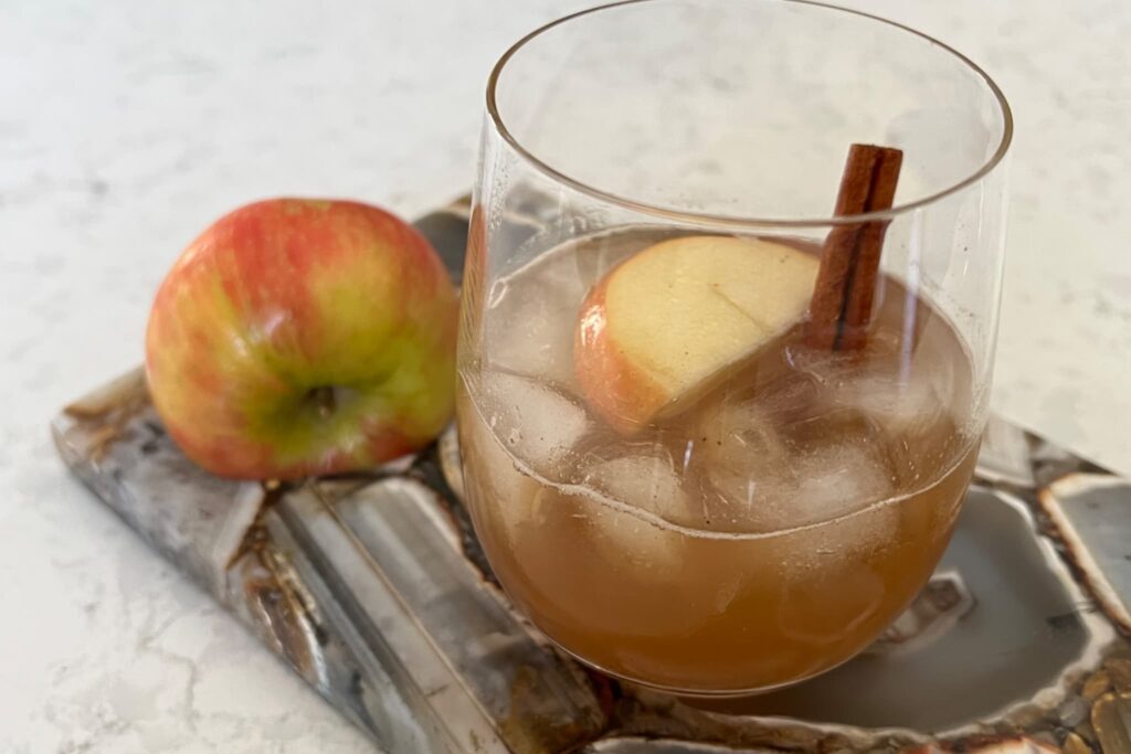 Apple Cider Mule with cinnamon stick and apple on agate board.