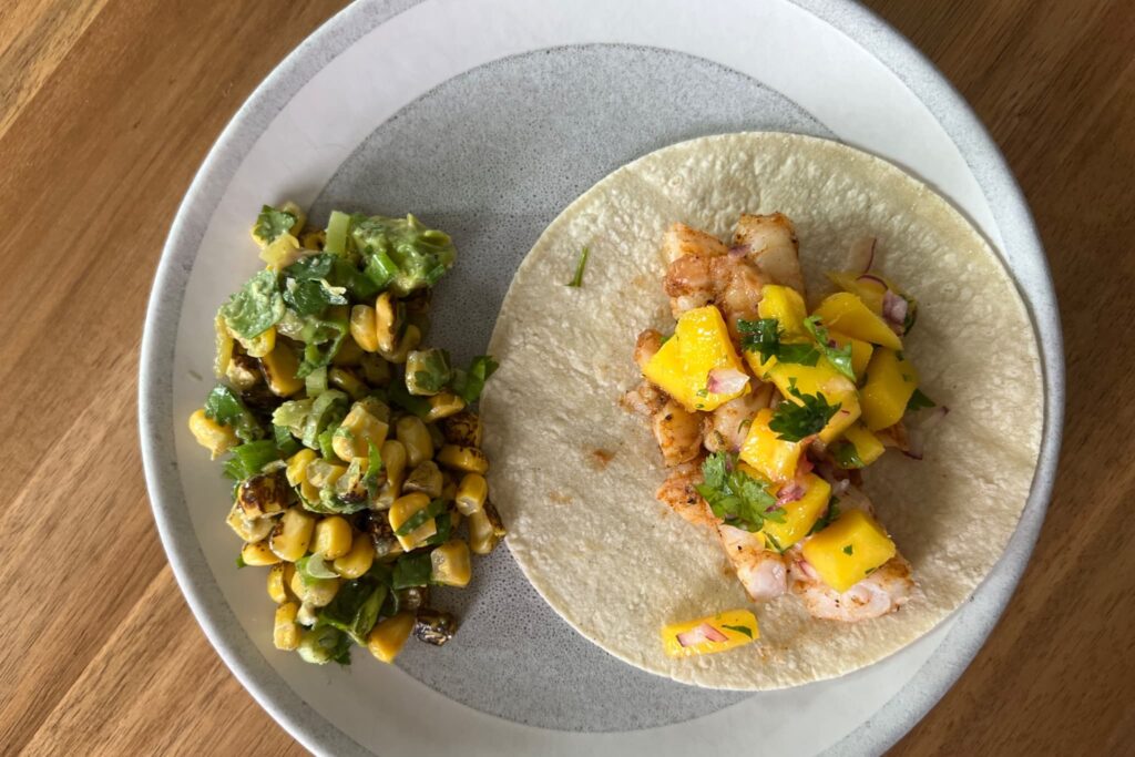 Shrimp and Mango Salsa Tacos with Mexican Street Corn on wood table.