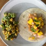 Shrimp and Mango Salsa Tacos with Mexican Street Corn on wood table.
