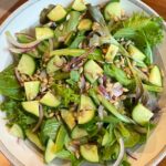 Mixed greens salad with cucumber onion and sunflower seeds.