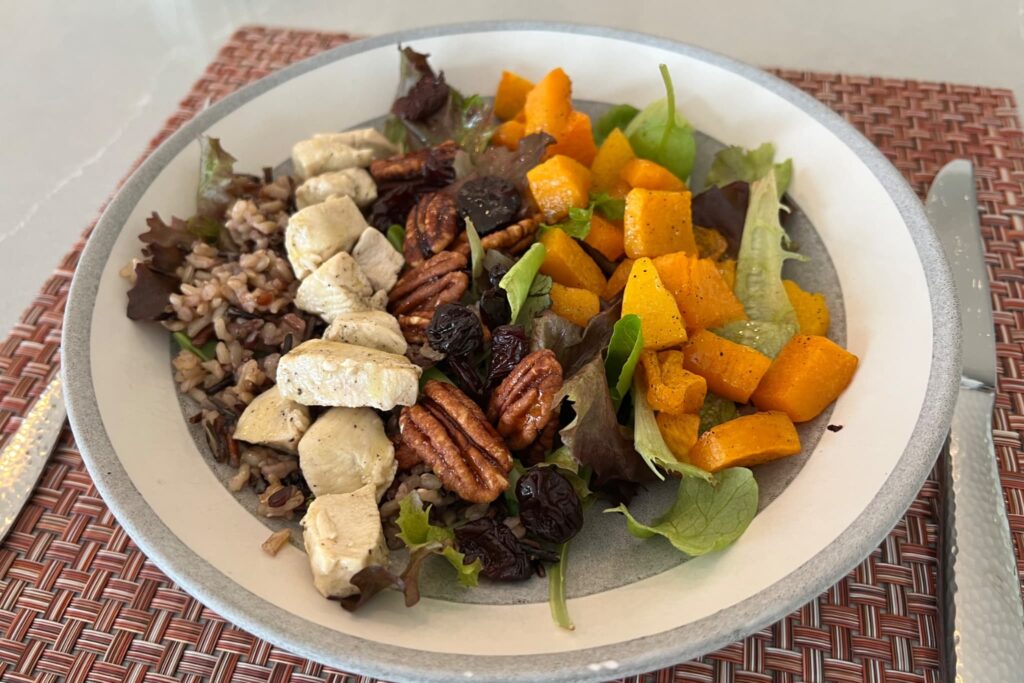 butternut squash and wild rice salad with dried cherries and pecans in gray bowl.