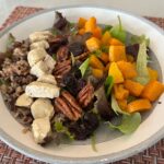 butternut squash and wild rice salad with dried cherries and pecans in gray bowl.