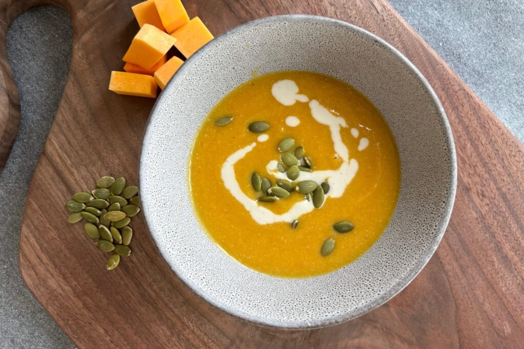 pureed butternut squash and apple soup with cashew cream and roasted pumpkin seeds.